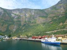 Flåm von der Fähre betrachtet (links neben den roten Gebäuden ist der Zug erkennbar)