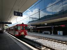 vor der verspiegelten Fassade des 2006 umgebauten Bahnhofs Visp