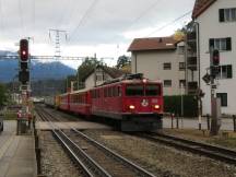 kurzer Personenzug mit angehängten Güterwagen erreicht Domat/Ems