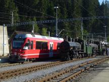 Alegra-Triebwagen (links) und historischer Dampfzug im Bf Reichenau-Tamins