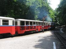 Zug mit offenen Sommerwagen verlässt Endbf Hűvösvölgy